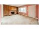 Cozy living room featuring a classic brick fireplace, wood paneling, and ample natural light at 1400 Russell Ave, Charlotte, NC 28216