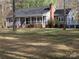 Charming gray home with a covered front porch, brick chimney, and a well-manicured lawn at 1414 Farmstead Rd, Rock Hill, SC 29732