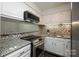Well-lit kitchen featuring stainless steel appliances, granite countertops, and mosaic tile backsplash at 1606 Sharon W Rd # 37, Charlotte, NC 28210