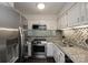 Modern kitchen with stainless steel appliances, granite countertops, and tiled backsplash at 1606 Sharon W Rd # 37, Charlotte, NC 28210
