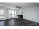 Spacious living room with a fireplace and large window offering natural light and dark laminate flooring at 1606 Sharon W Rd # 37, Charlotte, NC 28210