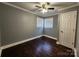 A bedroom featuring a ceiling fan, hardwood floors, gray walls, and natural light from windows at 1730 Martin Rd, Kings Mountain, NC 28086