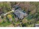 An aerial view shows a large house, pool, sport court, three car garage, and surrounding trees at 19117 Davidson Concord Rd, Davidson, NC 28036