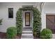 A beautiful front entrance features a black door with a garland covered arbor and stone steps at 19117 Davidson Concord Rd, Davidson, NC 28036