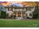 Stately two-story home with a columned front porch, manicured lawn, and elegant landscaping at 19117 Davidson Concord Rd, Davidson, NC 28036