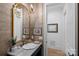 Chic powder room featuring marble countertops, a gold mirror, and textured wallpaper at 19117 Davidson Concord Rd, Davidson, NC 28036