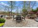 Landscaped backyard featuring a patio with a fire pit, dining set, and serene lake views at 21311 Baltic Dr, Cornelius, NC 28031