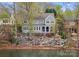 Stately blue home sits amongst a landscaped, tree filled yard overlooking the water at 21311 Baltic Dr, Cornelius, NC 28031