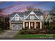 Exterior elevation showcases grand entrance with white pillars and stone accents and a grey garage door at 21311 Baltic Dr, Cornelius, NC 28031