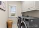 Functional laundry room with cabinetry and modern washer and dryer at 21311 Baltic Dr, Cornelius, NC 28031