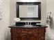 Elegant powder room with an ornate wooden vanity, dark countertop, and decorative mirror at 21311 Baltic Dr, Cornelius, NC 28031