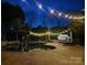 Backyard pool area illuminated by string lights, perfect for evening relaxation and entertainment at 2508 Shaggy Bark Ct, Belmont, NC 28012