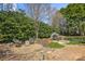 Beautiful backyard with lush greenery, a greenhouse, and cozy seating area at 2508 Shaggy Bark Ct, Belmont, NC 28012