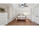 This bedroom features wood flooring, a ceiling fan, and a wood bed frame with white doors at 2508 Shaggy Bark Ct, Belmont, NC 28012