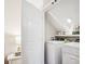 This bright laundry room features a white washer and dryer with storage shelves at 2508 Shaggy Bark Ct, Belmont, NC 28012