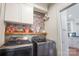 Well-organized laundry room with modern appliances, stylish wallpaper, and ample storage at 2508 Shaggy Bark Ct, Belmont, NC 28012