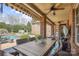 Covered brick patio with ceiling fan and outdoor dining area, overlooking a pool and landscaped backyard at 2508 Shaggy Bark Ct, Belmont, NC 28012
