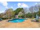 Backyard pool featuring an in-ground pool with a waterfall feature, lounge chairs, and mature trees at 2508 Shaggy Bark Ct, Belmont, NC 28012