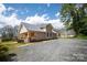 Side view of a home featuring a metal roof, light beige siding, and gravel driveway at 257 3Rd Se Ave, Hickory, NC 28602