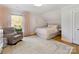 Cozy bedroom with soft pink accents, comfortable armchair, and hardwood floors at 3301 Mountainbrook Rd, Charlotte, NC 28210