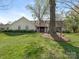 Beautiful white brick home with mature trees and green lawn at 3301 Mountainbrook Rd, Charlotte, NC 28210