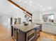 Well-lit kitchen boasts a large island, white cabinetry, stainless steel appliances and hardwood floors at 3301 Mountainbrook Rd, Charlotte, NC 28210