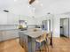 Bright kitchen featuring a large island, white cabinets, stainless steel appliances, and wood flooring at 3301 Mountainbrook Rd, Charlotte, NC 28210