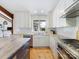 Modern kitchen with stainless steel appliances, herringbone backsplash, and hardwood flooring at 3301 Mountainbrook Rd, Charlotte, NC 28210