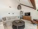 Comfortable living room features wood beams, vaulted ceilings, and a round coffee table with stylish decor at 3301 Mountainbrook Rd, Charlotte, NC 28210