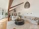 Bright living room with vaulted ceiling, wooden beams, modern lighting, and neutral-toned furniture at 3301 Mountainbrook Rd, Charlotte, NC 28210