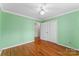 Bright bedroom features hardwood floors, a ceiling fan, and fresh green walls at 3772 Sandy Ford Rd, Hickory, NC 28602