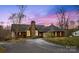 Stunning brick home with stone chimney, manicured landscaping, and a circular driveway under a gorgeous dusk sky at 3772 Sandy Ford Rd, Hickory, NC 28602