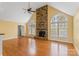 Light filled living room with vaulted ceilings, hardwood floors, a ceiling fan, and a large stone fireplace at 3772 Sandy Ford Rd, Hickory, NC 28602