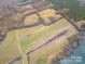 Aerial view showcases land parcel with fields, trees, and river access at 3A Riverlane Rd, Rock Hill, SC 29730