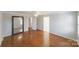 Open bedroom featuring hardwood floors, ceiling fan and an expansive mirror at 4351 Woodglen Ln, Charlotte, NC 28226