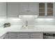 Close-up of kitchen featuring white cabinets, a sleek faucet, and subway tile, combining style with modern convenience at 4351 Woodglen Ln, Charlotte, NC 28226