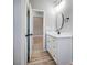 Charming bathroom featuring a white vanity with a round mirror, dark hardware, and light hardwood flooring at 437 Cedar Grove Rd, Clover, SC 29710