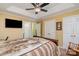 Comfortable bedroom featuring a ceiling fan, tv and a king-size bed with a decorative blanket at 4501 Brandie Glen Rd, Charlotte, NC 28269