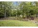 View of the wooded backyard with a mulch path and lush greenery at 463 Lake Wylie Rd, Belmont, NC 28012