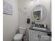 Charming powder room with a decorative mirror, vanity, and toilet at 463 Lake Wylie Rd, Belmont, NC 28012
