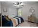 Cozy bedroom featuring a ceiling fan, a bed with striped quilt, and a window overlooking lush greenery at 463 Lake Wylie Rd, Belmont, NC 28012