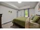 Comfortable bedroom featuring tray ceilings, natural light from the window, and hardwood floors at 463 Lake Wylie Rd, Belmont, NC 28012