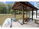 Lake view with covered boat dock featuring a boat lift, Adirondack chairs and watercraft for lake activities at 463 Lake Wylie Rd, Belmont, NC 28012