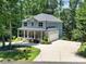 Charming two-story home with a stone facade, covered porch, and lush landscaping in a wooded setting at 463 Lake Wylie Rd, Belmont, NC 28012