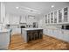 Modern kitchen with white cabinets, hardwood floors, an island with seating, and stainless steel appliances at 463 Lake Wylie Rd, Belmont, NC 28012