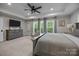 Spacious main bedroom with large windows, a ceiling fan, and a dresser with a wall-mounted television at 463 Lake Wylie Rd, Belmont, NC 28012