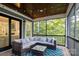 Cozy screened porch with comfortable seating and a view of the surrounding trees and property at 463 Lake Wylie Rd, Belmont, NC 28012