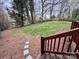 A spacious, grassy backyard view from a wooden deck with stairs and a bordering fence with lots of trees at 4805 Horizon Cir, Charlotte, NC 28215