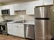 Well-lit kitchen featuring stainless steel appliances, white cabinets, and wood-look floors at 4805 Horizon Cir, Charlotte, NC 28215