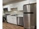 Well-lit kitchen featuring stainless steel appliances, white cabinets, and wood-look floors at 4805 Horizon Cir, Charlotte, NC 28215